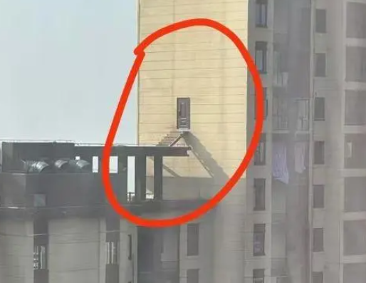 28樓業(yè)主破墻開(kāi)門 搭梯通往隔壁樓頂 這也太危險(xiǎn)了